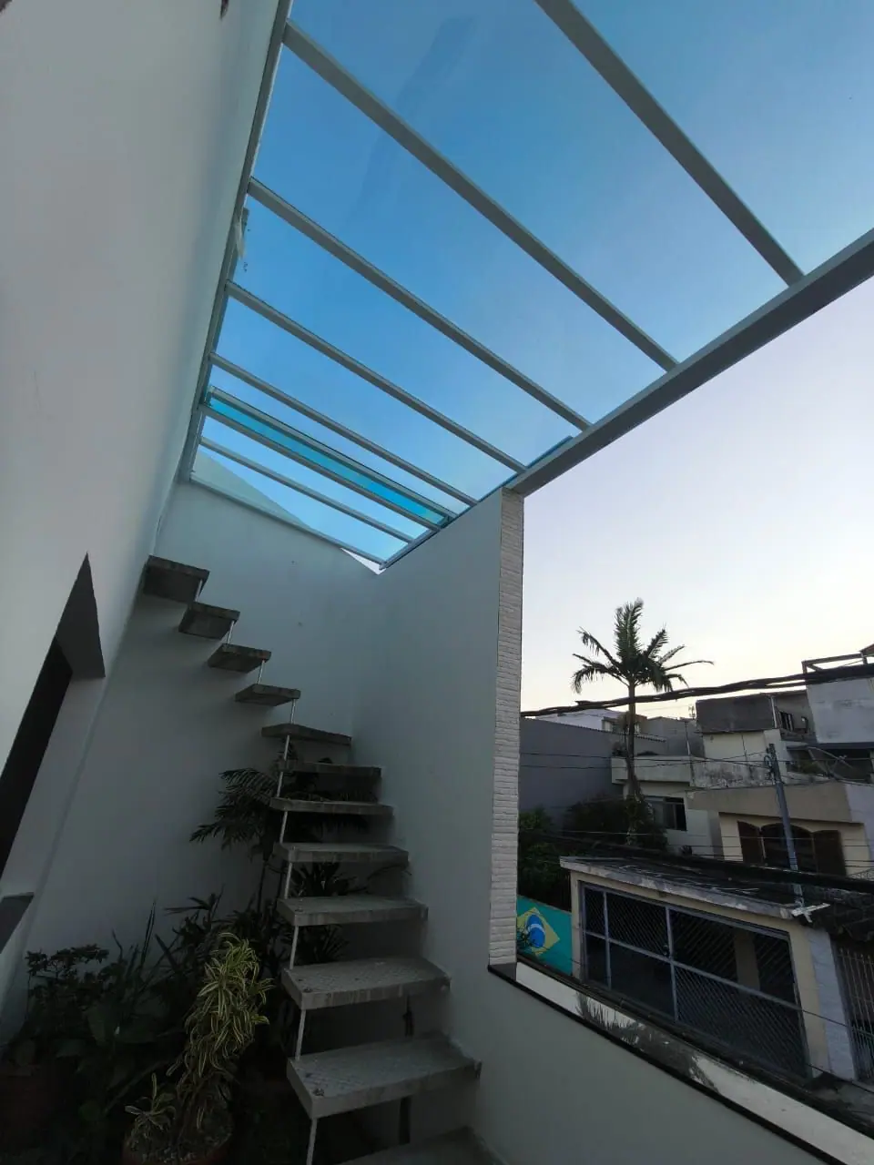 Cobertura retrátil transparente ao lado de escada externa em São Paulo