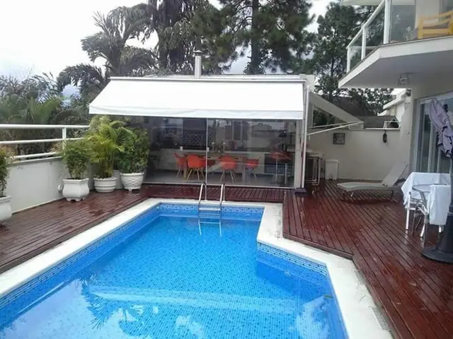 Toldo retrátil de braço articulado branco na área da piscina em São Paulo