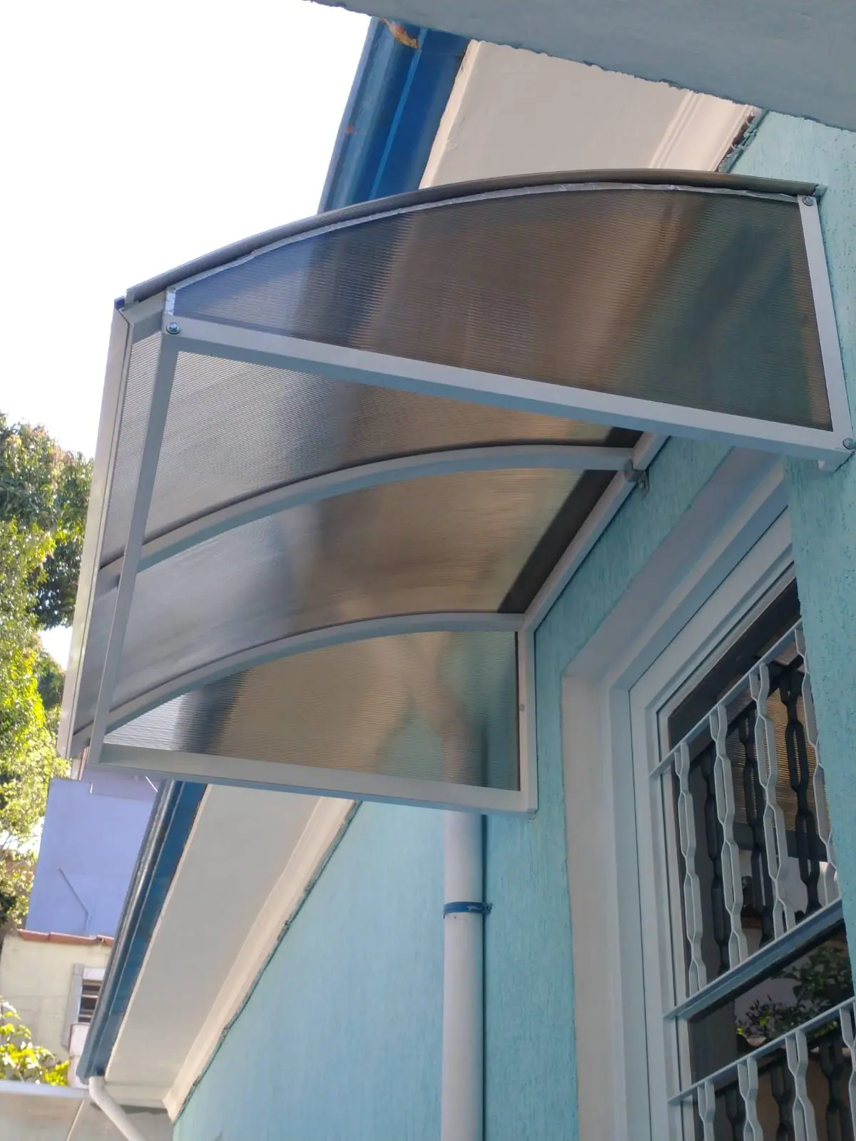 Toldo de policarbonato em arco sobre janela em São Paulo