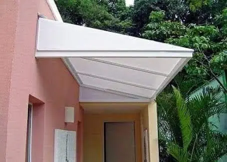 Toldo de policarbonato branco sobre porta lateral em São Paulo